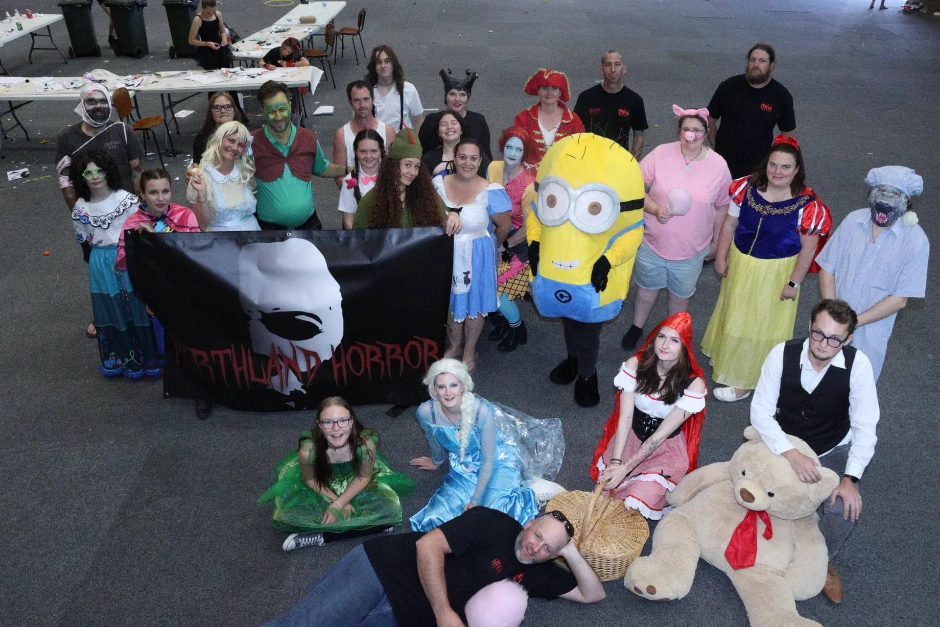 The Northland Horror volunteer crew of about twenty-five people in costume gathered around their black banner in McKay Stadium, ranging from Snow White and a Minion to zombies and ghouls